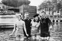 Two British sailors and their girlfriends wading in the fountains in Trafalgar Square on VE Day, 8 May