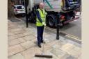 Mayor John Biggs tidying up the York stone pavement in Navarre Street