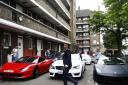 Aminul Mishu Alam, 16, walks past cars parked at a social housing estate before a parade of 