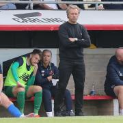 Dagenham & Redbridge manager Daryl McMahon looks on from the dugout at Victoria Road