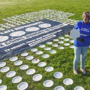 The installation\'s central poster reads: \'Each plate represents 10,000 people going hungry in Britain.\'