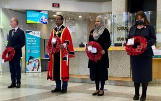 Cllrs Peter Golds, Mohammed Ahbab Hossain and Asma Begum with wreaths alongside Denise Radley, the council's deputy chief executive and corporate director for health, adults and community.